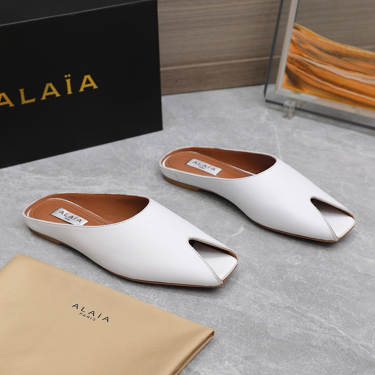 ALAIA FLAT MULE IN WHITE LAMBSKIN