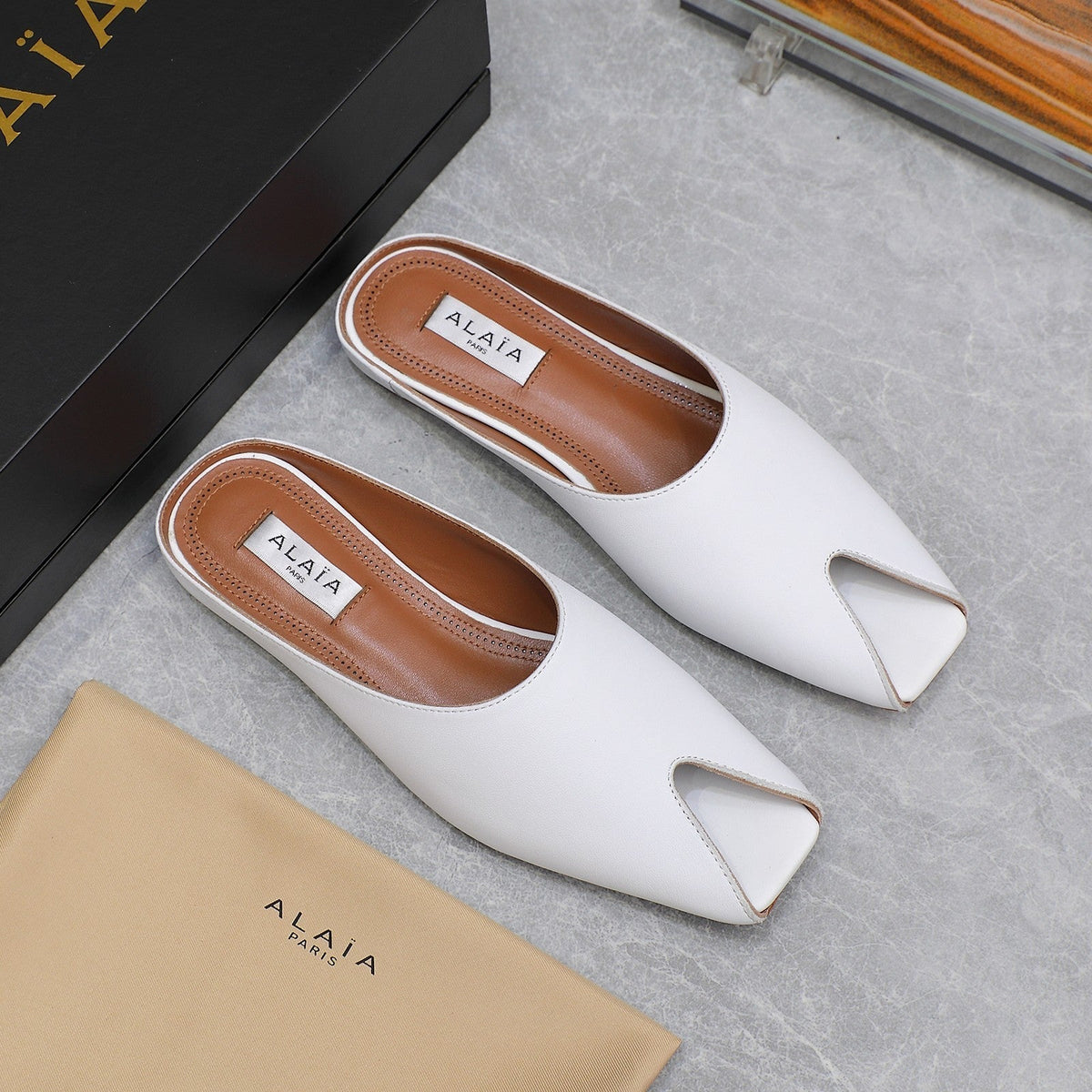 ALAIA FLAT MULE IN WHITE LAMBSKIN