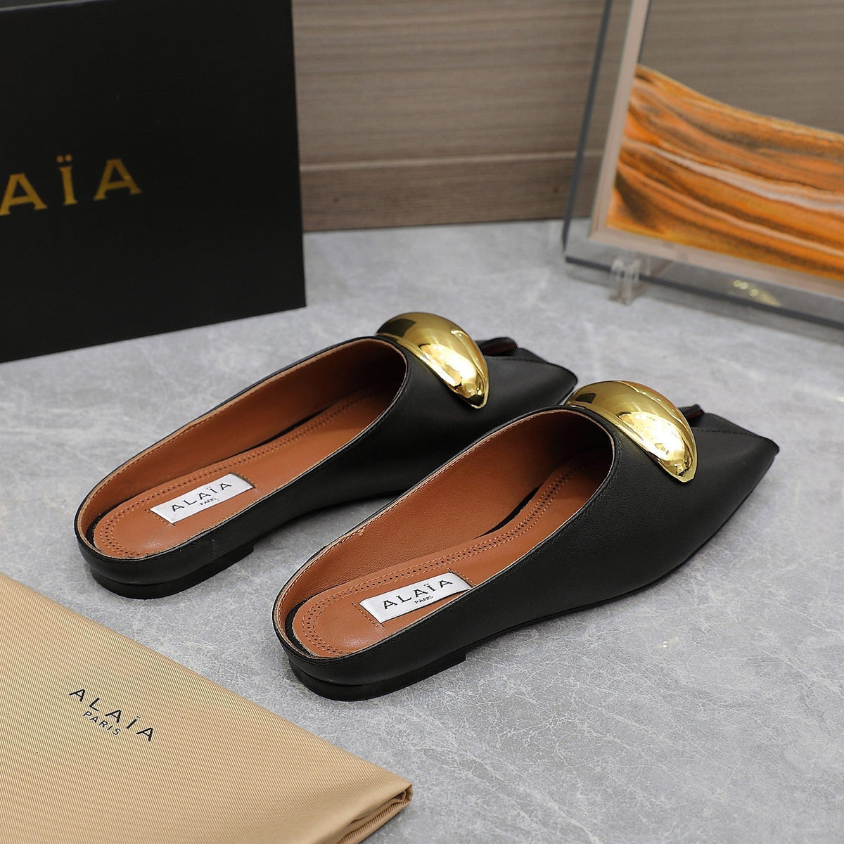 ALAIA FLAT MULE IN BLACK LAMBSKIN WITH GOLD HARDWARE